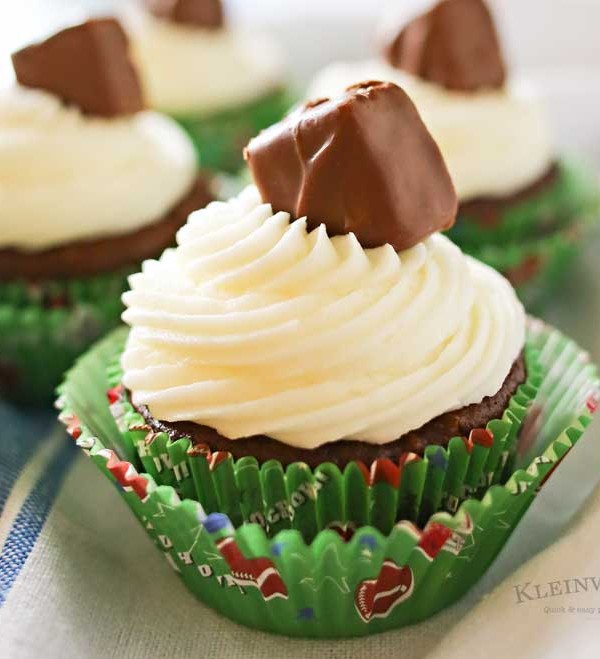 Looking for some game day food ideas? Game Day Snickers Cupcakes are an easy 3 - ingredient cupcake recipe loaded with Snickers candy bars, topped with a delicious & easy buttercream frosting & more Snickers minis. on kleinworthco.com