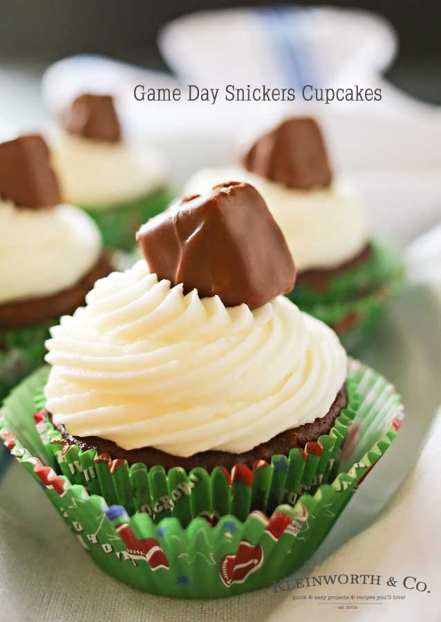 Looking for some game day food ideas? Game Day Snickers Cupcakes are an easy 3 - ingredient cupcake recipe loaded with Snickers candy bars, topped with a delicious & easy buttercream frosting & more Snickers minis. on kleinworthco.com