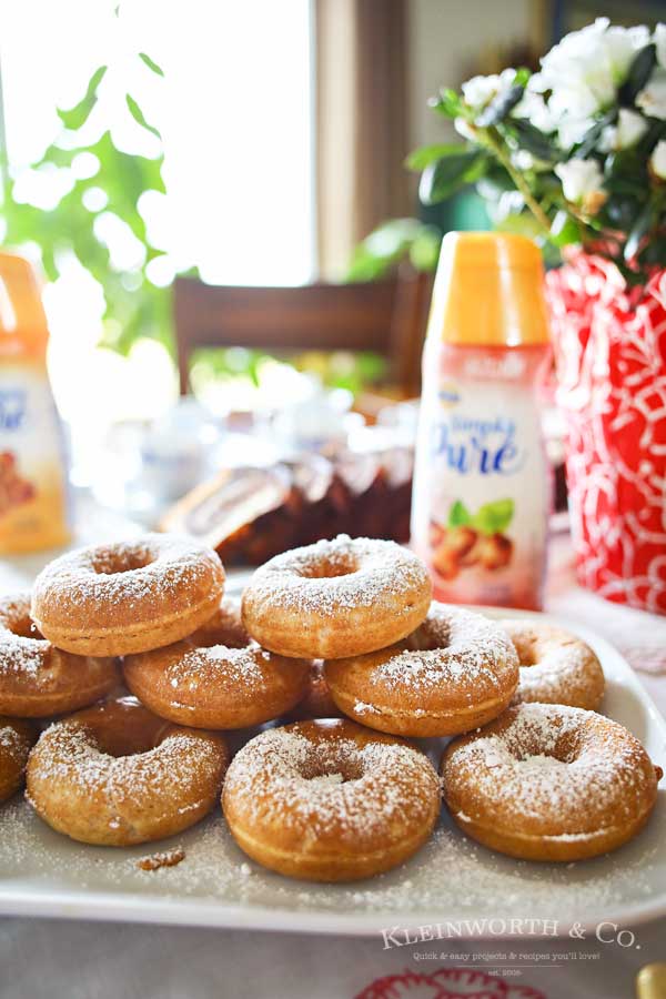 Caramel Whole Wheat Donuts are a lightened up version of the traditional baked cake donut recipe. Using whole wheat flour & just a dusting of confectioners sugar in place of frosting, they are perfect with your morning coffee or at your next brunch. Don't miss my tips for planning a coffee party too.