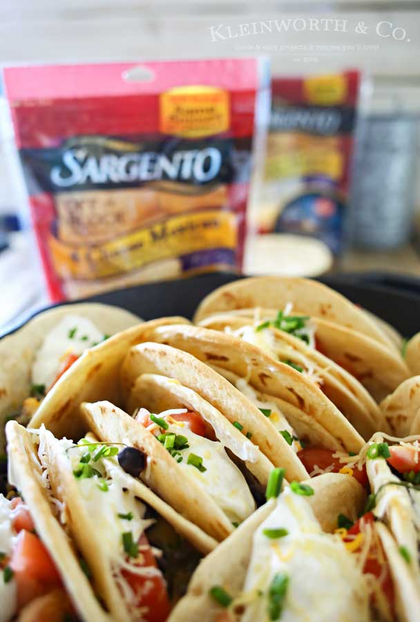 Baked Chicken Street Tacos are an easy family dinner idea. Quick to make using rotisserie chicken smothered in homemade crema & baked in the iron skillet. Seriously SO GOOD we made them twice in one weekend!
