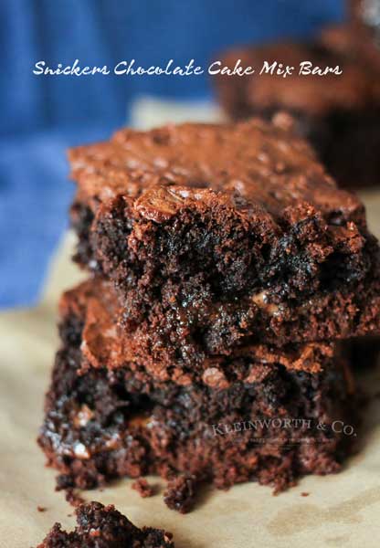 Snickers Chocolate Cake Mix Bars are like a super thick but chewy brownie. A simple cake mix brownie loaded with candy bars that are just another yummy bar recipe you don't want to miss. YUM! I absolutely swoon over these.