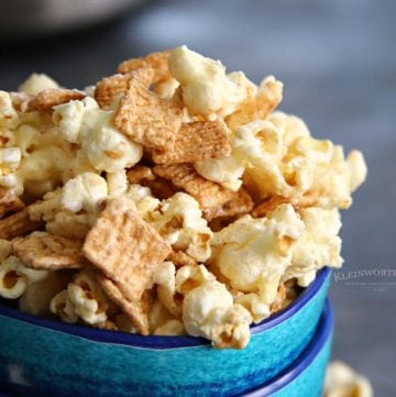 A bowl of Cinnamon Toast Crunch popcorn, coated with a sweet cinnamon glaze, showing the crunchy cereal pieces mixed with the popcorn for a sweet and savory snack.