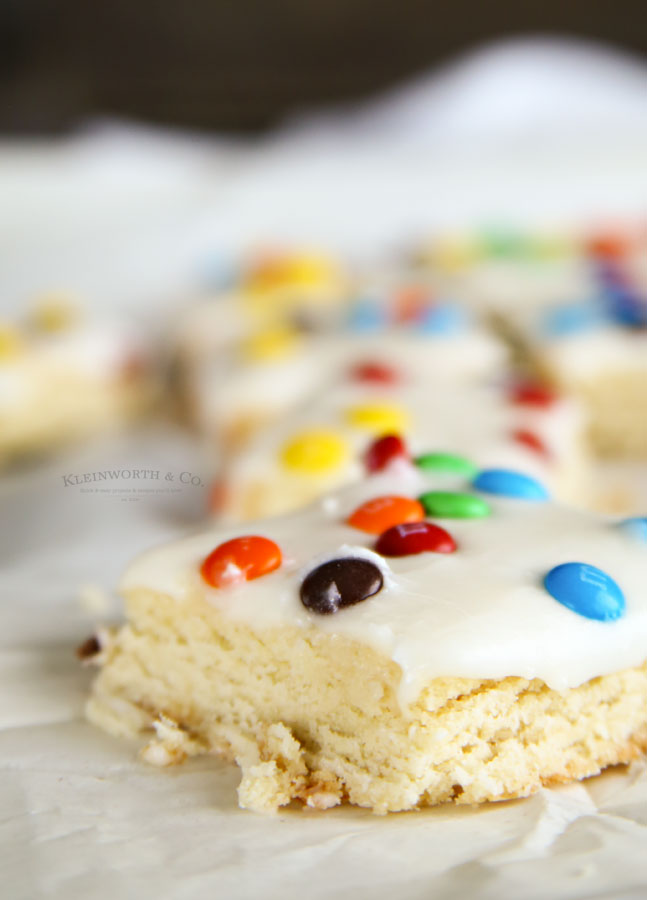 M&M Sugar Cookie Bars - deliciously frosted soft sugar cookie base, topped with mini m&m’s. You can’t go wrong with these.