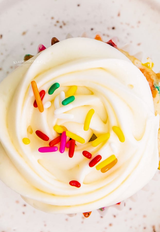 cream cheese frosting on confetti cupcake