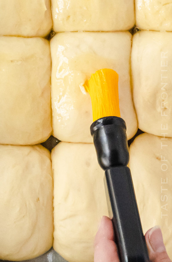 brushing rolls with butter