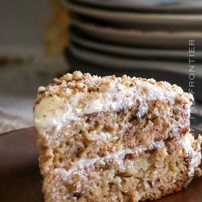 cake decorated with cream cheese frosting and pecans