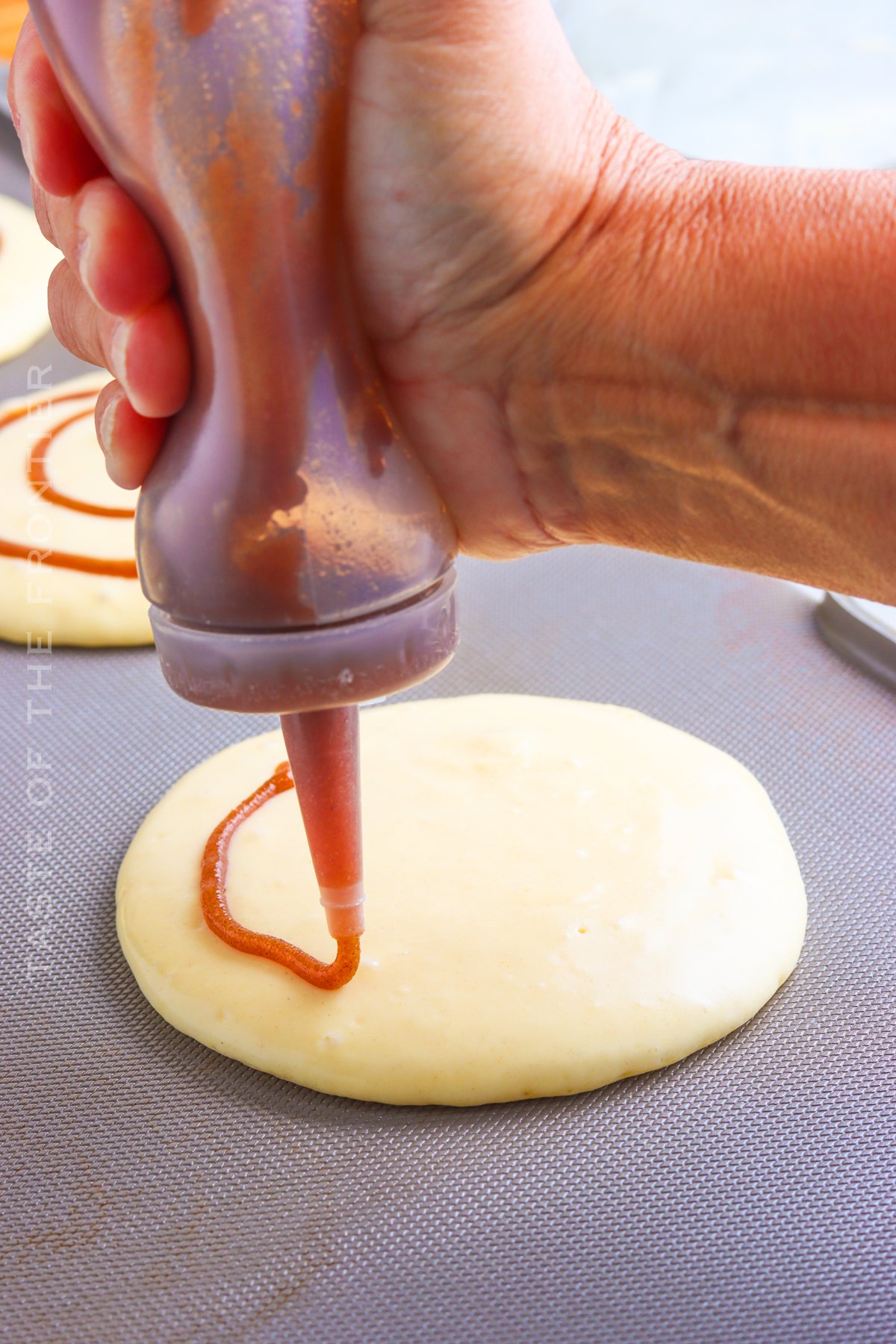 adding filling to Cinnamon Roll Pancakes