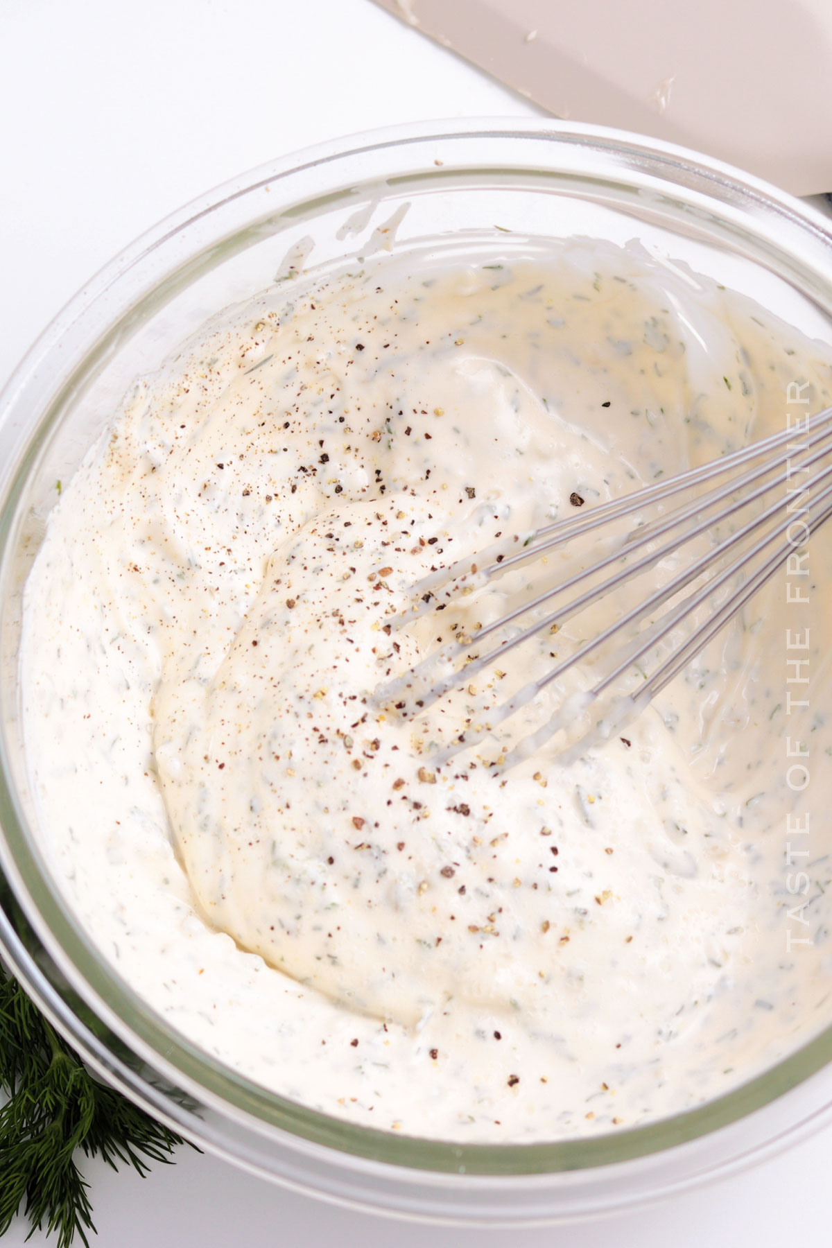 adding pepper to tartar sauce