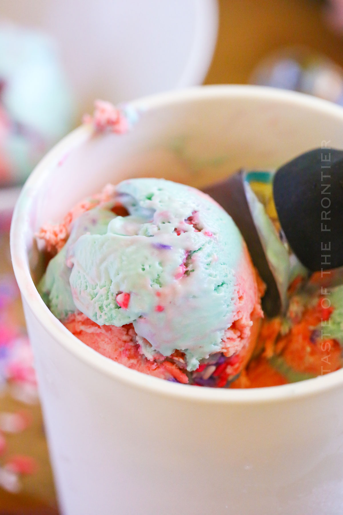 scooping homemade ice cream with sprinkles