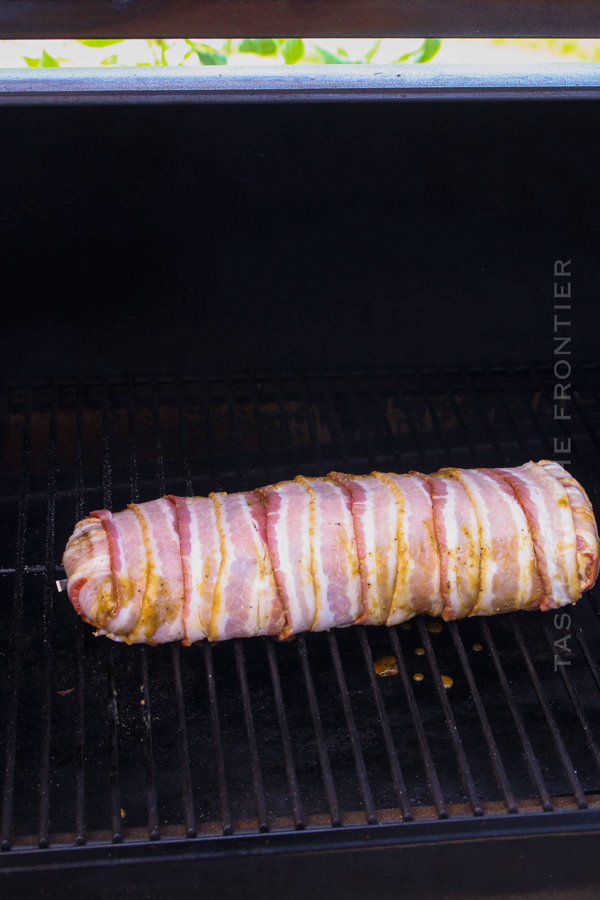 bacon wrapped pork on smoker