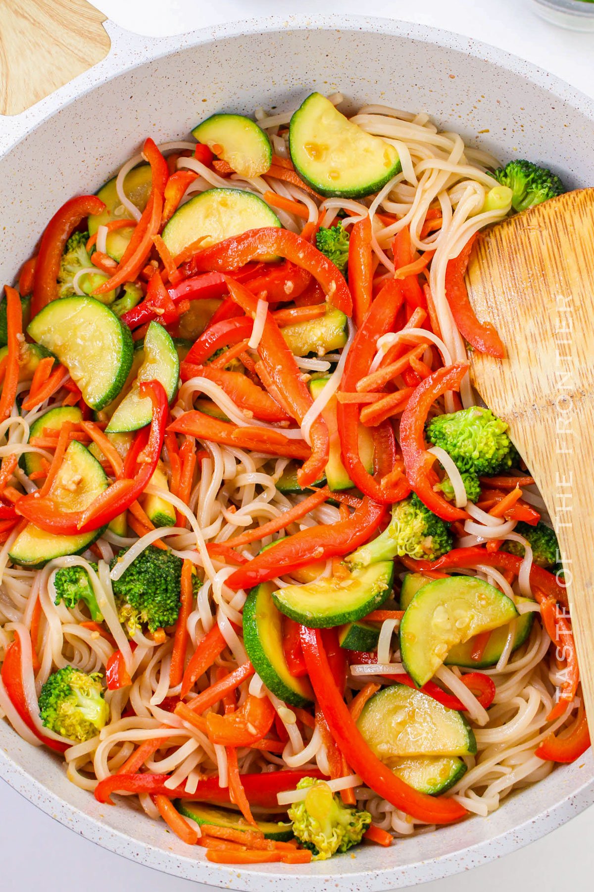 mixing the veggies and noodles